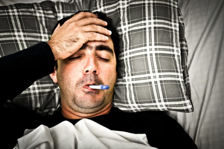 hombre enfermo en cama con fiebre
