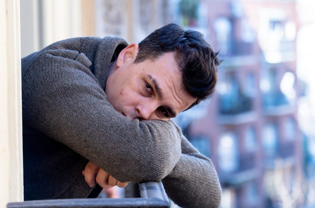 Hombre deprimido mirando por un balcón depresión, ansiedad, hombre triste