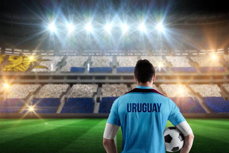 Uruguay football player holding ball against stadium full of uruguay football fans